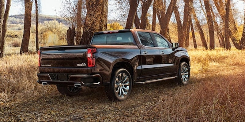 Rear-side view of gray Chevrolet Silverado 1500 parked in lot